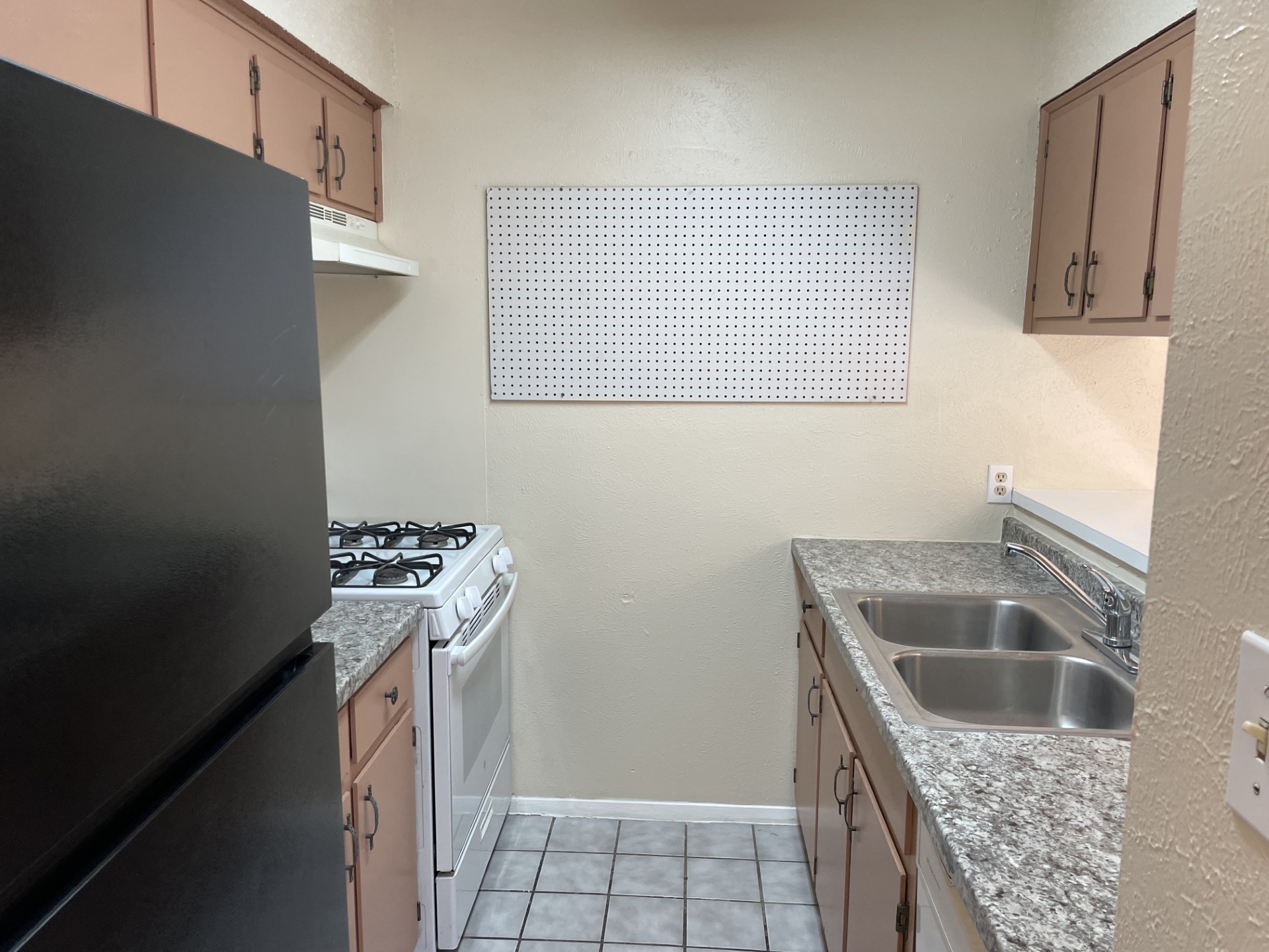 809 Plumpton Drive Austin, TX 78745 - Photo 6 of 14 Kitchen featuring freestanding refrigerator, white range with gas stovetop, a textured wall, and light tile patterned floors