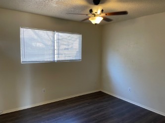 809 Plumpton Drive Austin, TX 78745 - Photo 9 of 14 Bedroom 2 featuring a textured ceiling, ceiling fan, and dark wood finished floors