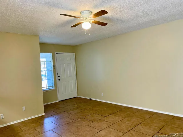 an empty room with a empty space and a ceiling fan