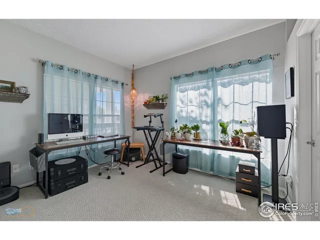 a living room with furniture a flat screen tv and large windows