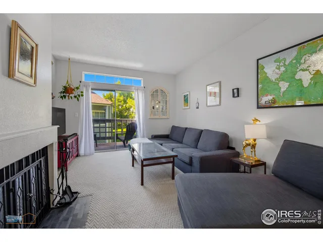 a living room with furniture a flat screen tv and a large window