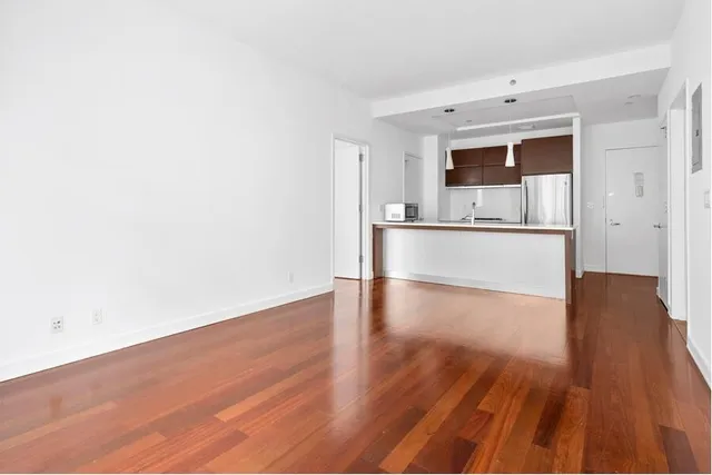 a view of a kitchen with wooden floor and electronic appliances