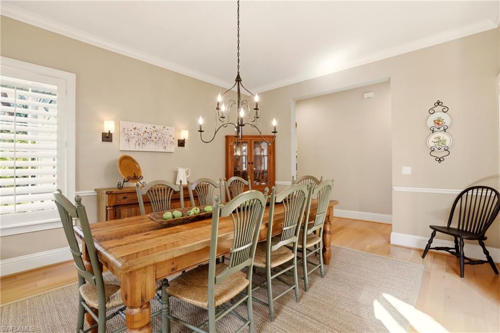 4335 7th Avenue Southwest Naples, FL 34119 - Photo 14 of 49 Dining area with crown molding, light wood-type flooring, and a chandelier