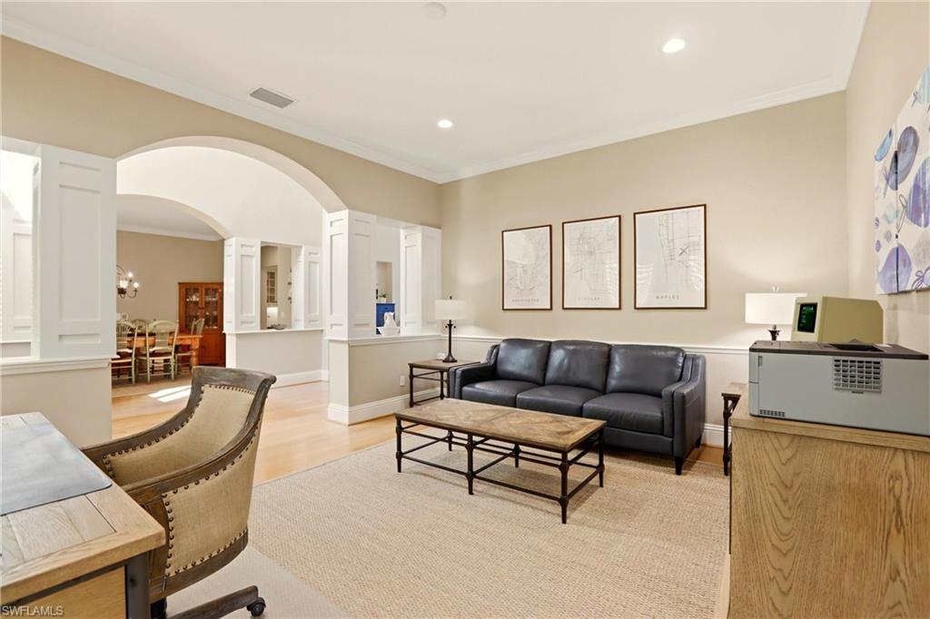 4335 7th Avenue Southwest Naples, FL 34119 - Photo 19 of 49 Living area with arched walkways, ornamental molding, decorative columns, light wood-type flooring, and recessed lighting