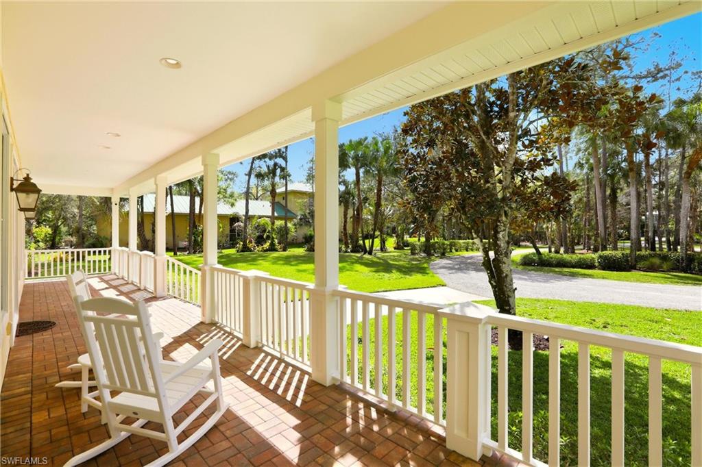4335 7th Avenue Southwest Naples, FL 34119 - Photo 3 of 49 Wooden porch featuring a lawn