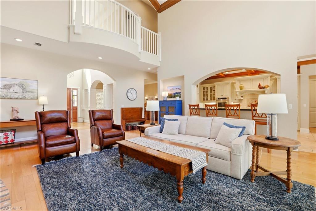 4335 7th Avenue Southwest Naples, FL 34119 - Photo 8 of 49 Living room with arched walkways, light wood-type flooring, and a high ceiling