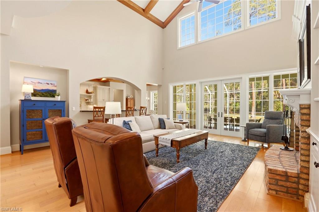 4335 7th Avenue Southwest Naples, FL 34119 - Photo 9 of 49 Living area with light wood finished floors, french doors, arched walkways, and lofted ceiling