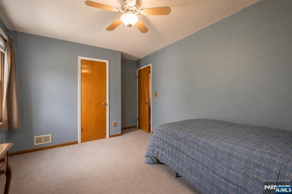 55 Marcia Road Ringwood, NJ 07456 - Photo 20 of 42 a bed room with a bed and a chandelier