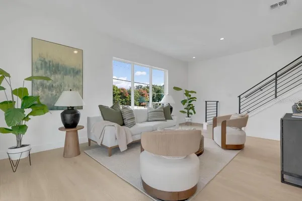 a living room with furniture potted plant and a large window
