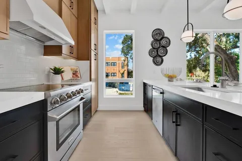 a kitchen with a dining table chairs sink and cabinets