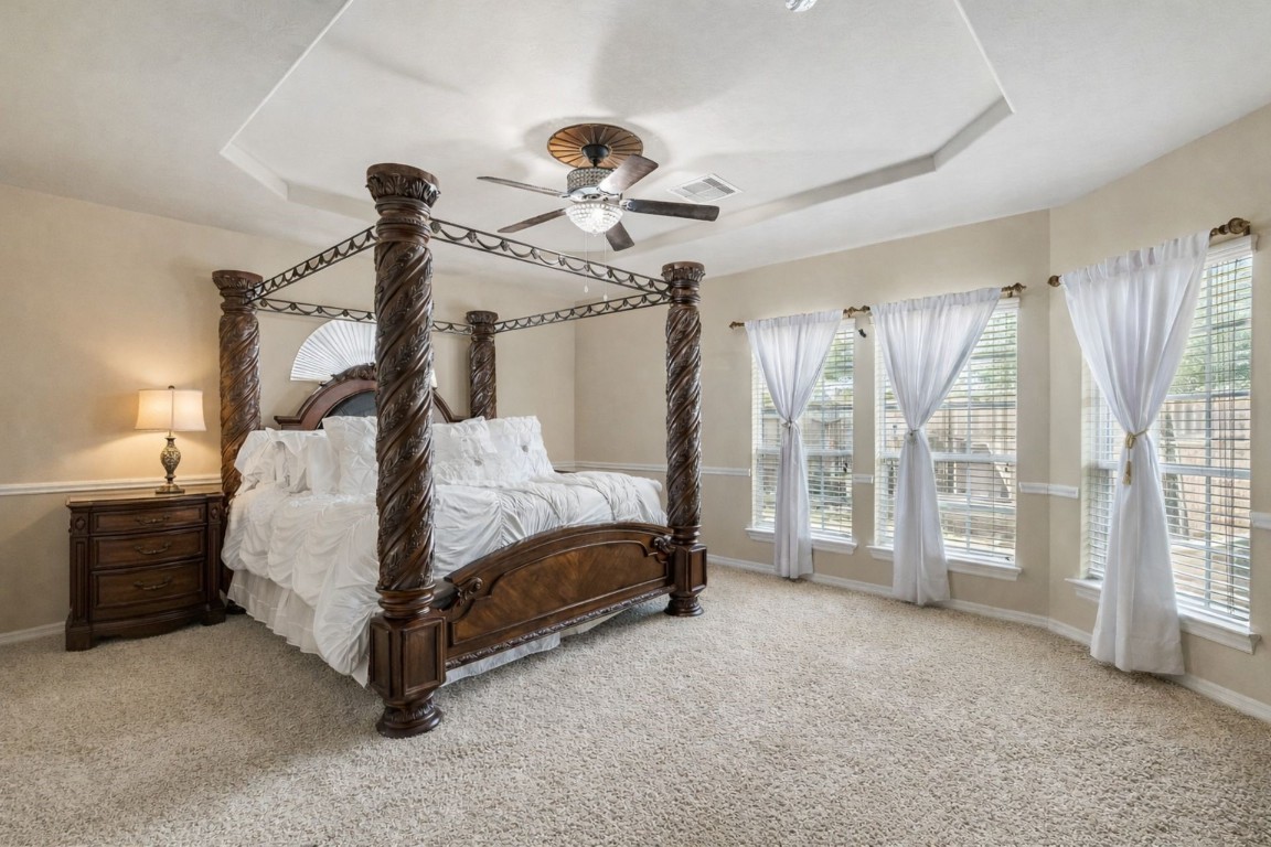 8211 Paddle Rock Lane Rosenberg, TX 77469 - Photo 11 of 24 a bedroom with a bed and a chandelier