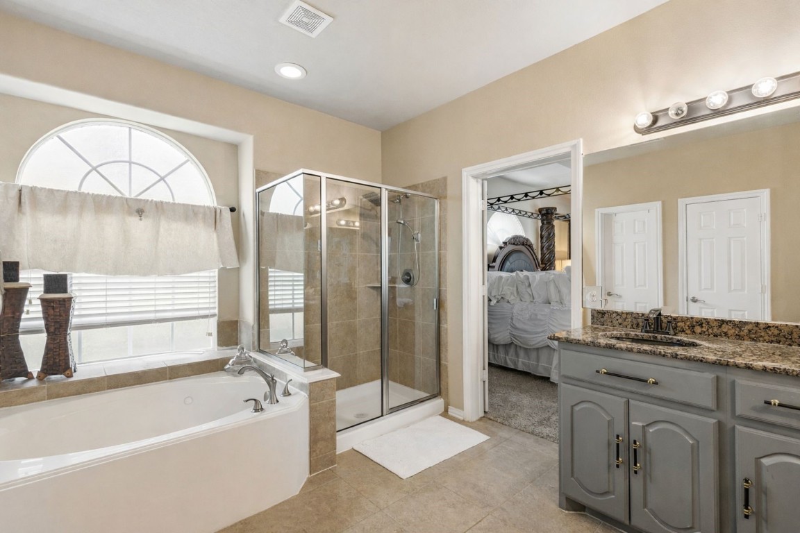 8211 Paddle Rock Lane Rosenberg, TX 77469 - Photo 12 of 24 a spacious bathroom with a granite countertop sink mirror bathtub and shower