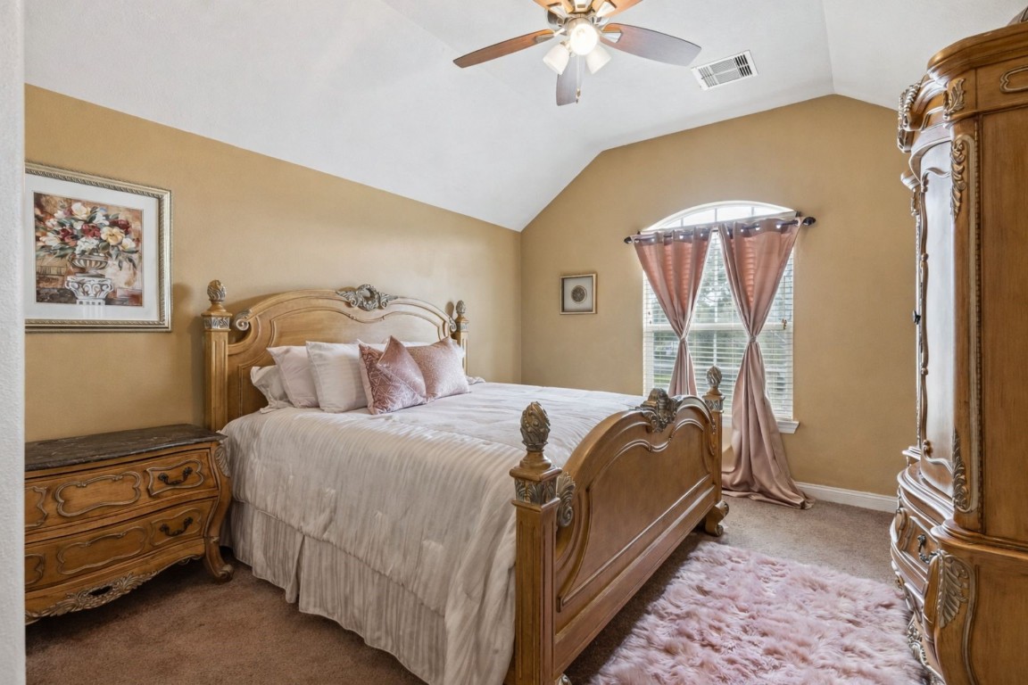 8211 Paddle Rock Lane Rosenberg, TX 77469 - Photo 15 of 24 a bedroom with a bed and a chandelier