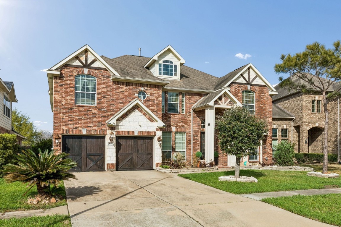 8211 Paddle Rock Lane Rosenberg, TX 77469 - Photo 21 of 24 a front view of a house with a yard and garage