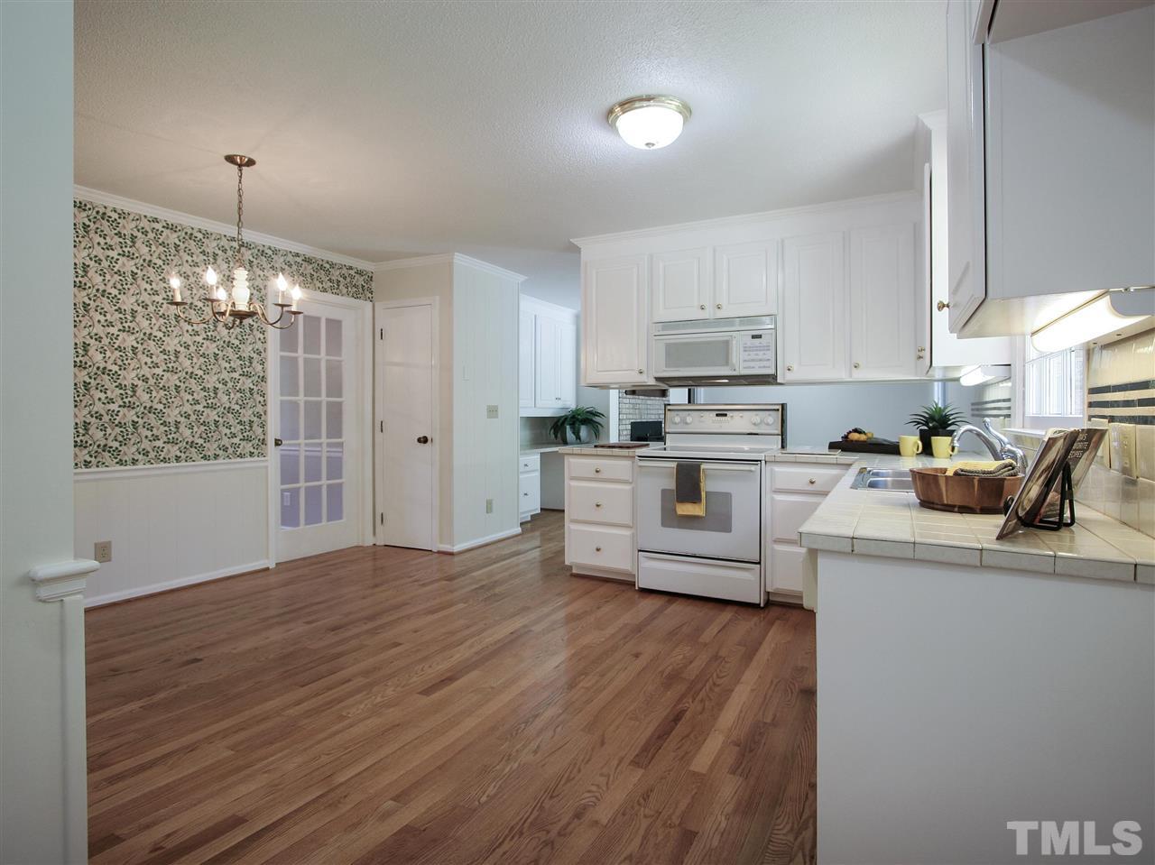 1324 Kingston Ridge Road Cary, NC 27511 - Photo 10 of 30 Overall view of the kitchen and breakfast area, and the family room beyond. Note the glass door to the dining room and the convenient location of the pantry.