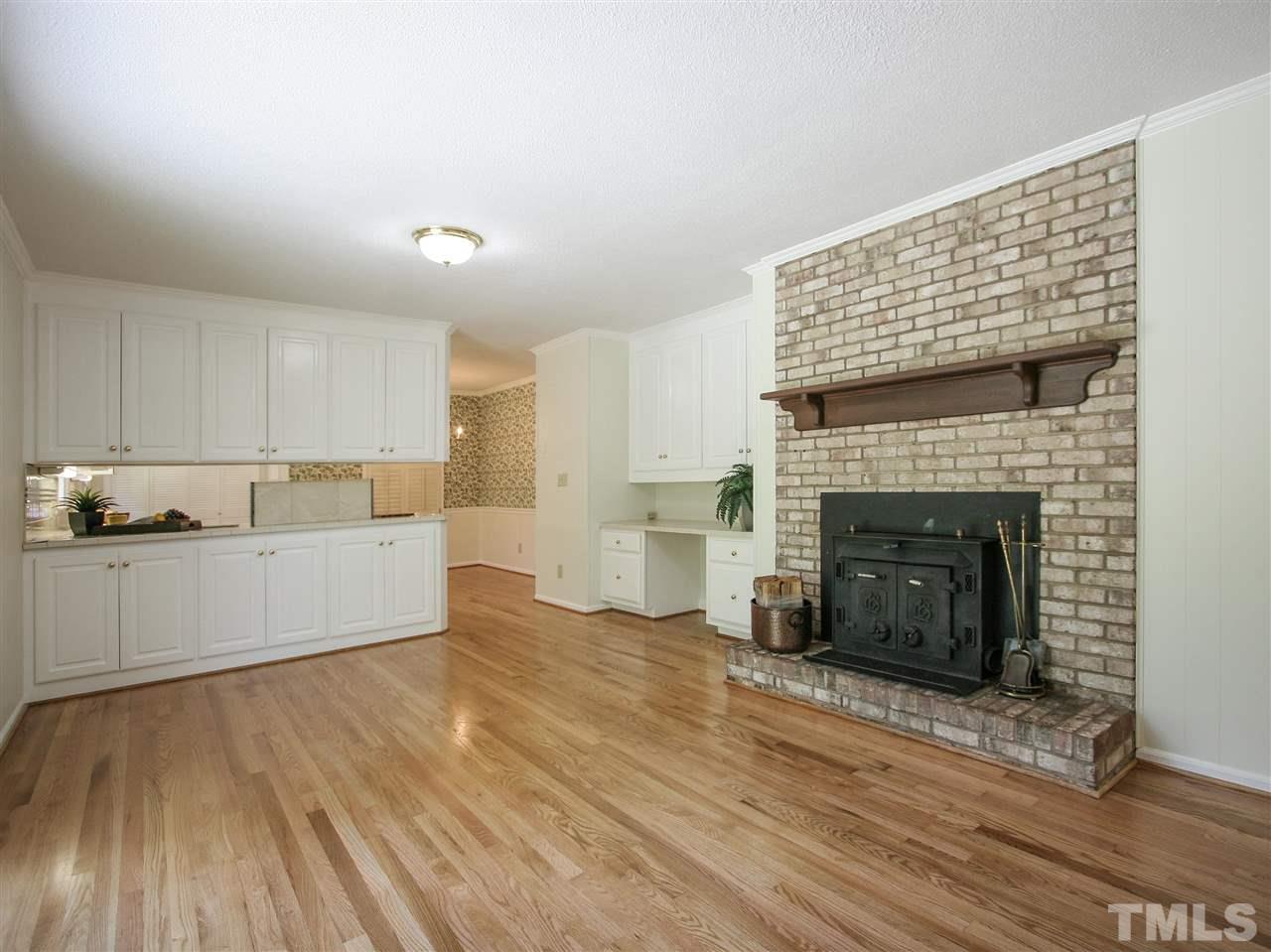 1324 Kingston Ridge Road Cary, NC 27511 - Photo 11 of 30 The heart of the home, this wonderful family room has a cozy fireplace with wood-burning insert and classic wood mantel. Note all the convenient built-in cabinet space and shelving this room offers. A sliding glass door leads to the verdant backyard.