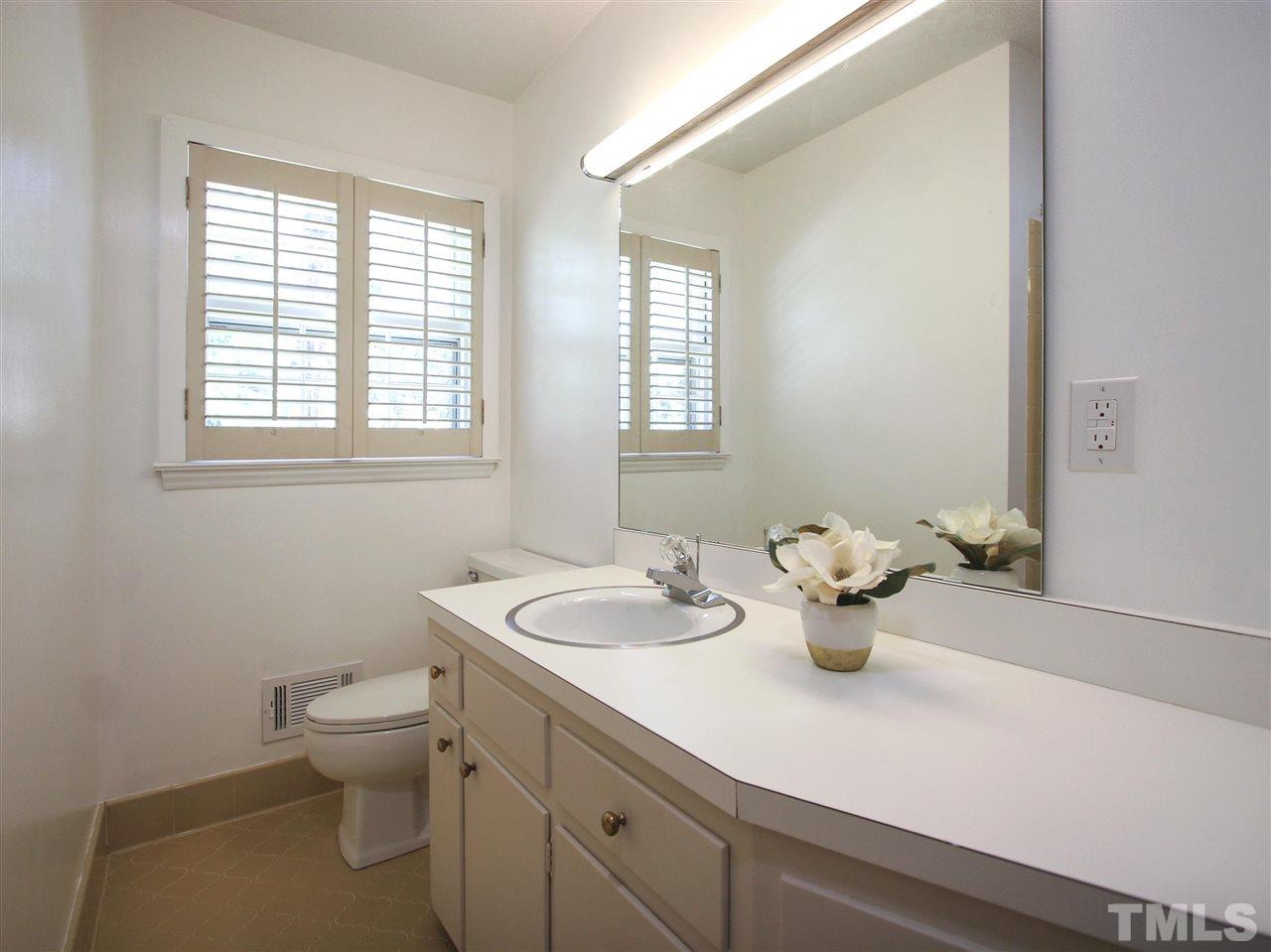 1324 Kingston Ridge Road Cary, NC 27511 - Photo 18 of 30 Hall bath has tile floor, plate mirror, window with Plantation shutters, and plenty of counter space.