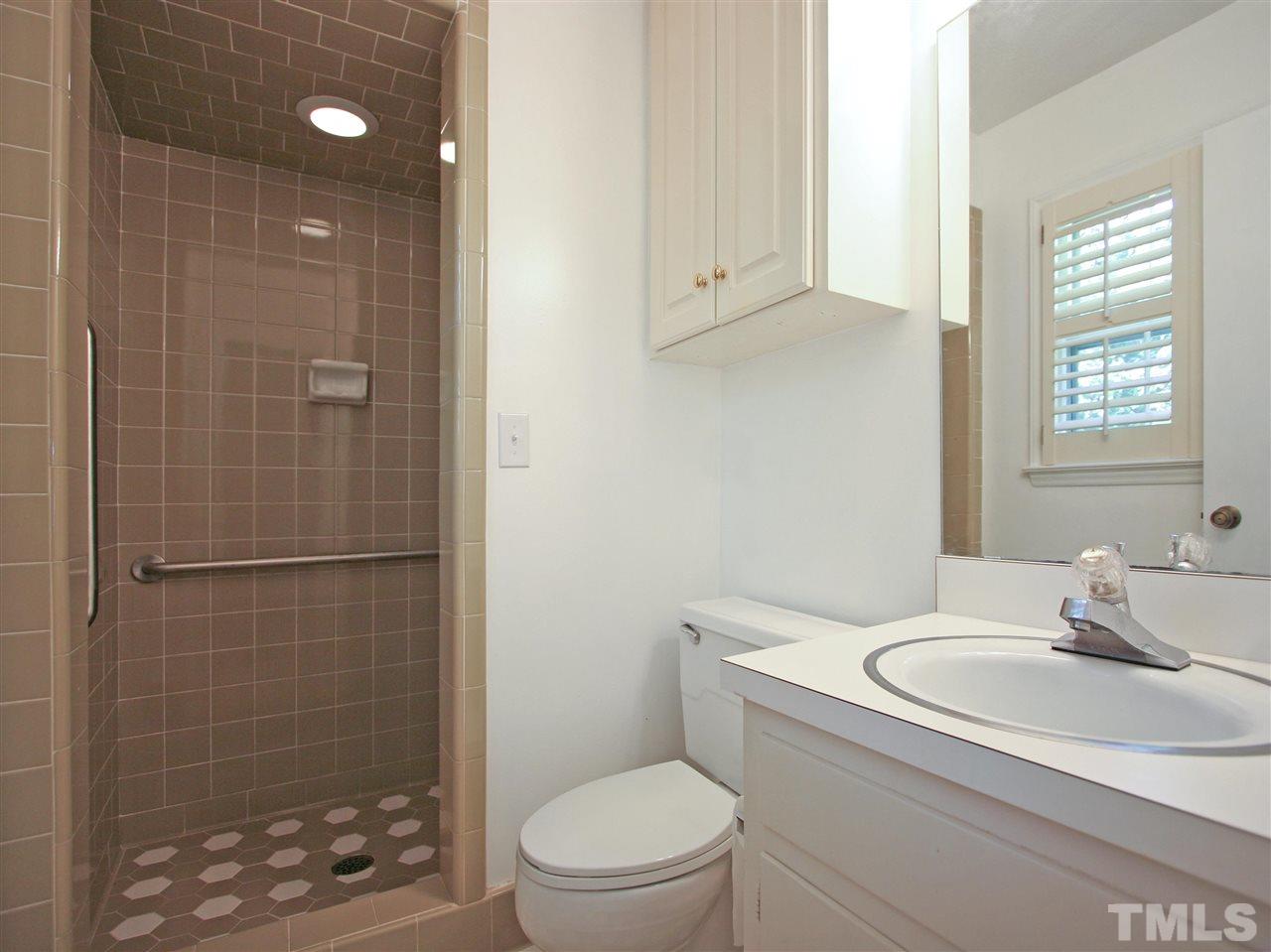 1324 Kingston Ridge Road Cary, NC 27511 - Photo 22 of 30 The owner's suite bath has tile floor, a standup shower, a vanity, and a wall cabinet.