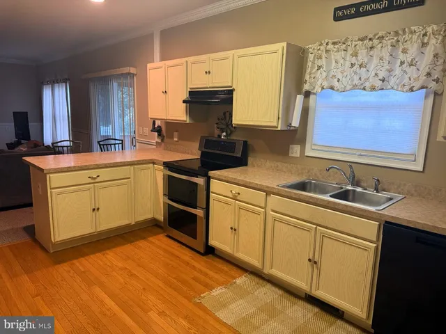 a kitchen with stainless steel appliances granite countertop a sink stove and cabinets