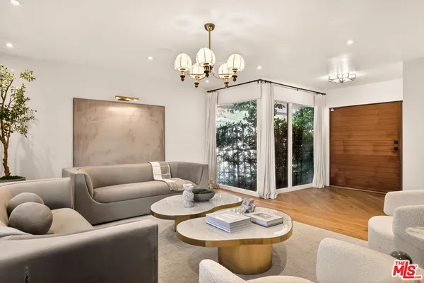 a living room with furniture potted plant and a chandelier