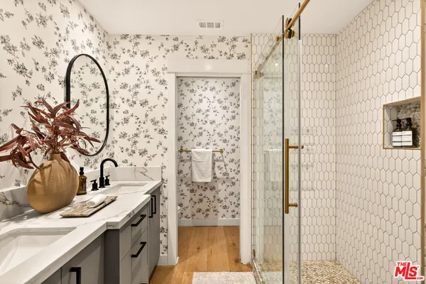 a bathroom with a sink a mirror and shower