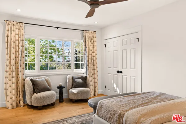 a bedroom with furniture and a large window