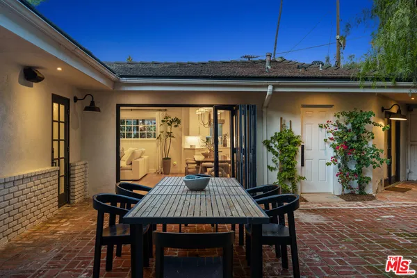 a view of a patio with a table and chairs and potted plants