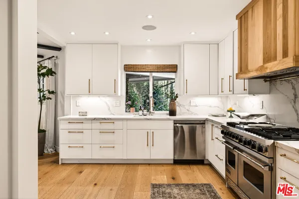 a kitchen with stainless steel appliances granite countertop a stove a sink and a refrigerator