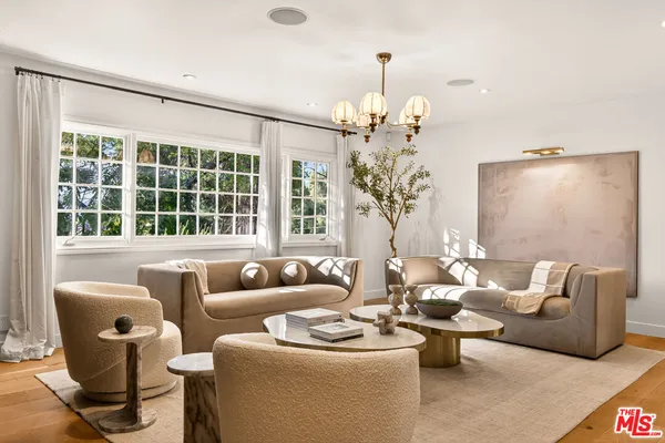 a living room with furniture and a chandelier