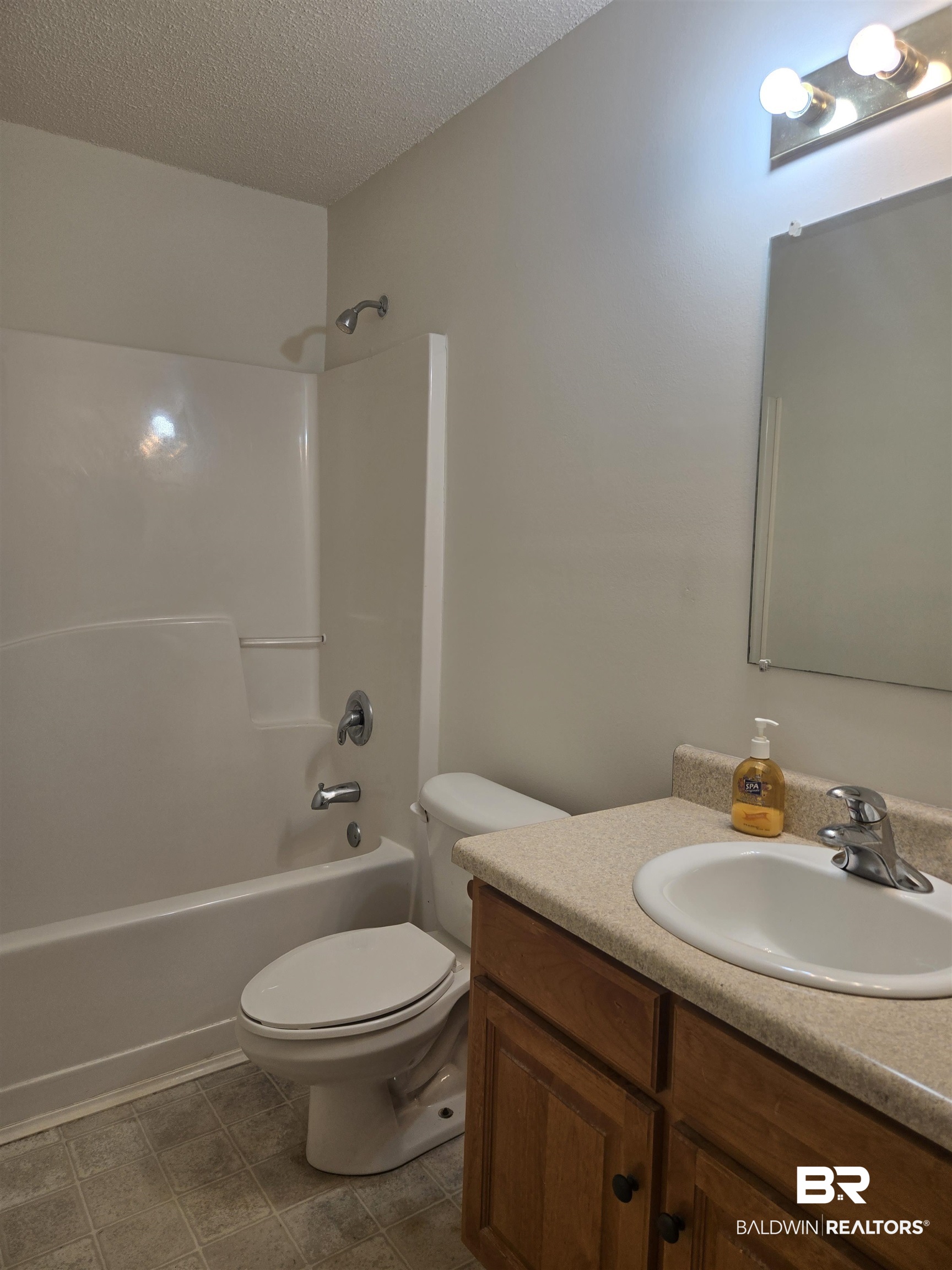 2554 Riverside Drive Mobile, AL 36605 - Photo 15 of 43 Bathroom featuring shower / bathtub combination, a textured ceiling, and vanity