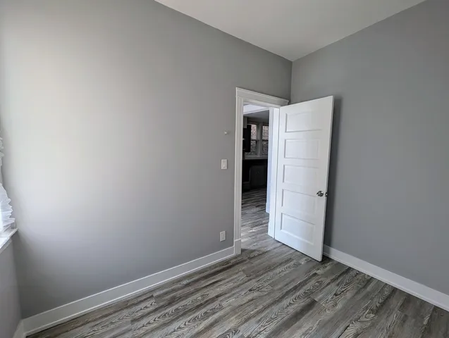 a kitchen with a refrigerator a stove top oven and wooden floor