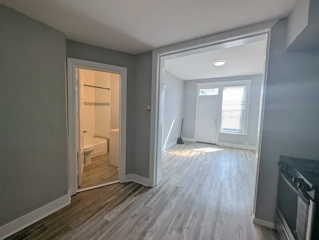 an empty room with wooden floor and entrance