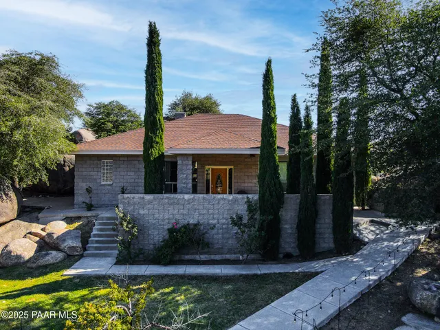 a front view of a house with a garden and yard