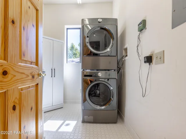 a view of a dining room and livingroom with furniture wooden floor a chandelier