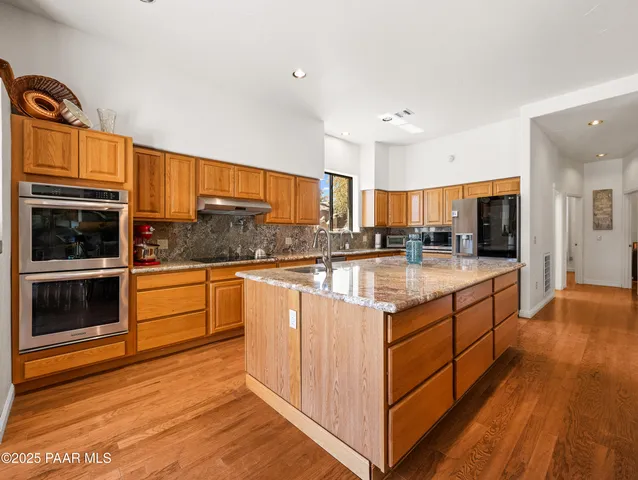 a kitchen with stainless steel appliances granite countertop a stove and cabinets