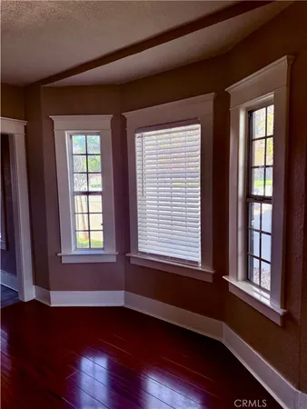 a view of a livingroom with a fireplace wooden floor and a window