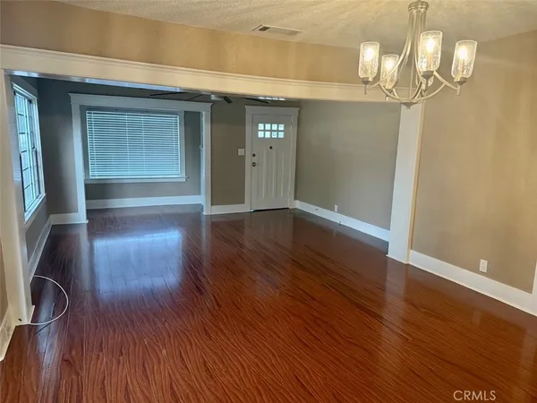 a view of empty room with wooden floor and closet