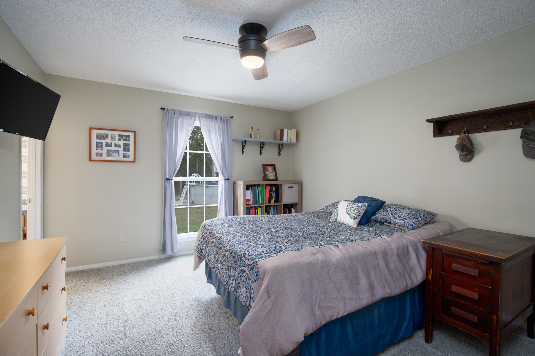 2826 Penney Lane Crestview, FL 32539 - Photo 13 of 22 a bedroom with a bed a dresser and a chandelier