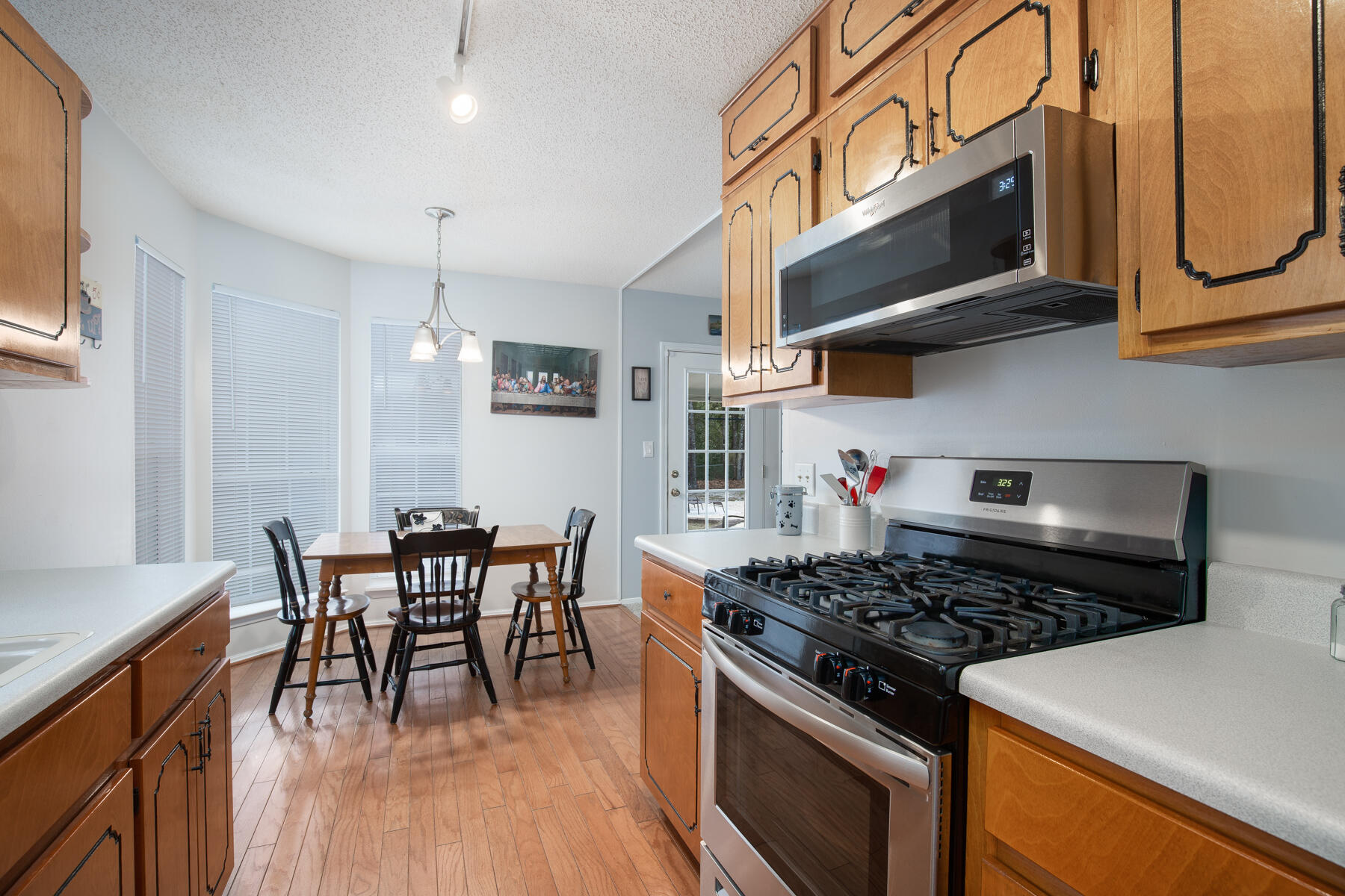 2826 Penney Lane Crestview, FL 32539 - Photo 10 of 22 a kitchen with stainless steel appliances granite countertop a stove a sink dishwasher and white cabinets with wooden floor