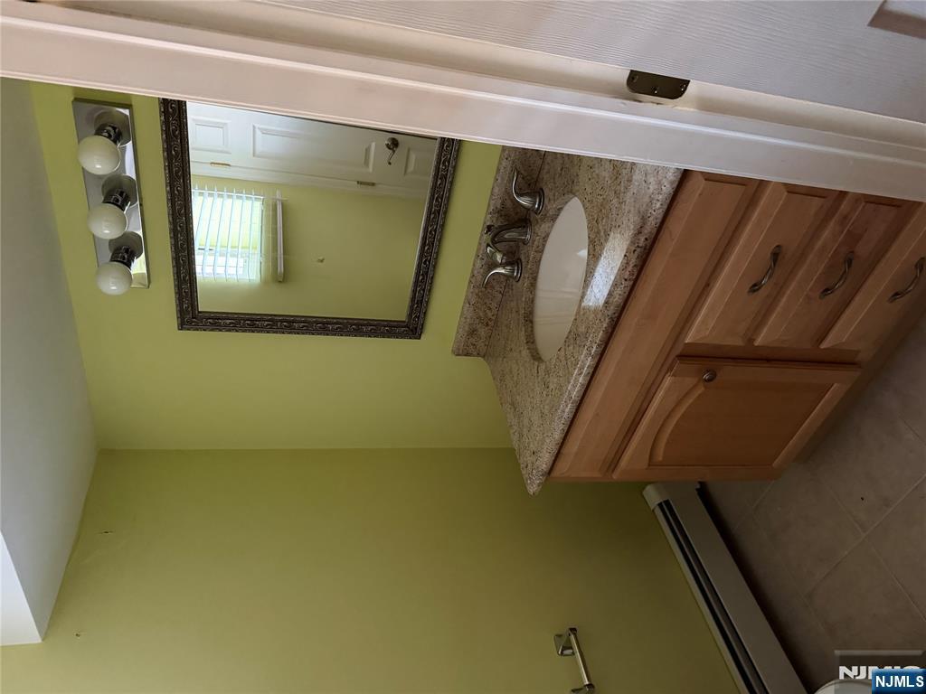 37 Park Row, Unit 2 Wallington, NJ 07057 - Photo 22 of 33 a bathroom with a granite countertop sink and a mirror
