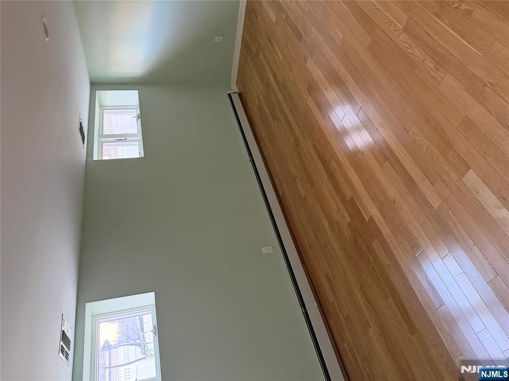 37 Park Row, Unit 2 Wallington, NJ 07057 - Photo 31 of 33 an empty room with wooden floor and windows