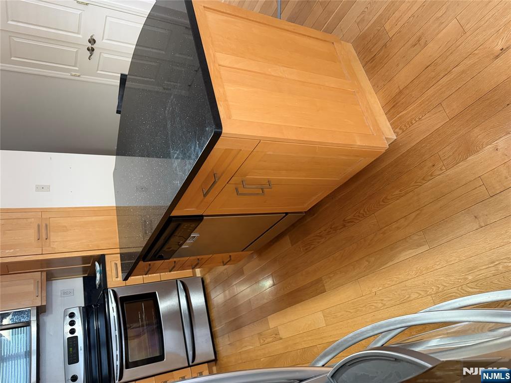 37 Park Row, Unit 2 Wallington, NJ 07057 - Photo 33 of 33 a kitchen with granite countertop stainless steel appliances and wooden cabinets