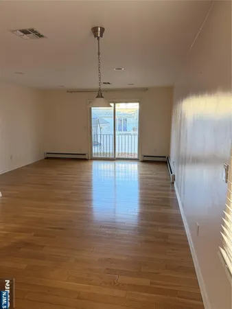 a view of empty room with wooden floor