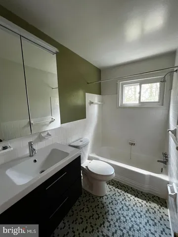 an empty room with wooden floor chandelier fan and windows