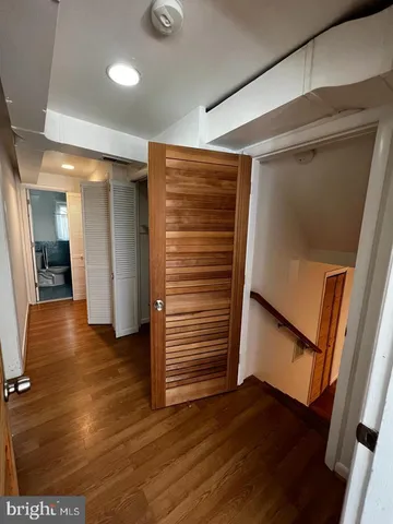 a view of empty room with wooden floor and window