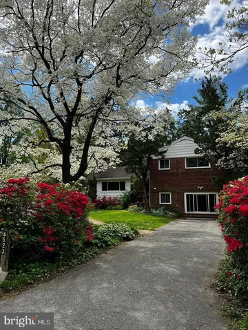 a front view of a house with a yard and potted plants