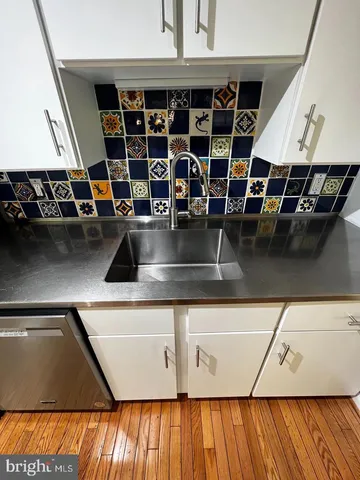 a view of water heater room with wooden floor
