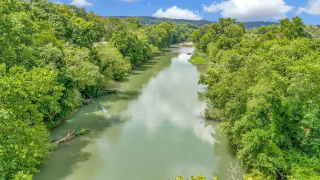 an aerial view of residential house with outdoor space and trees all around
