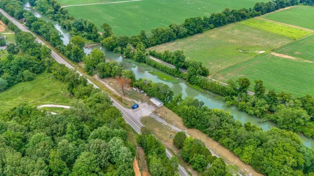 an aerial view of green landscape with trees houses and mountain view
