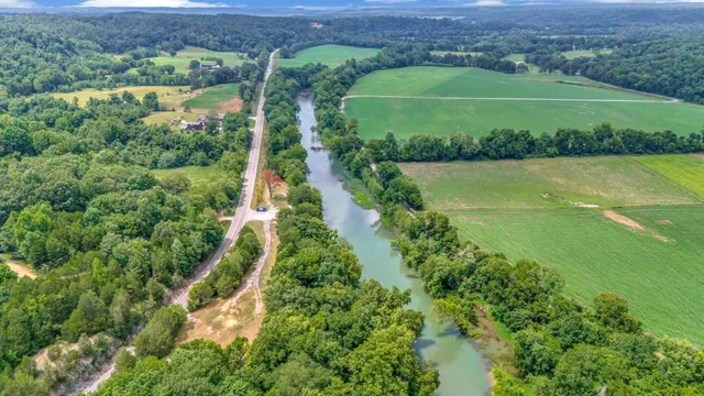 an aerial view of a houses with a lush green hillside